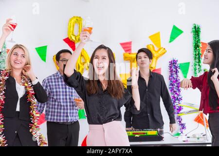 Asian imprenditrice danza nel messaggio di saluto aziendale festa di capodanno con il personale del collega. Foto Stock