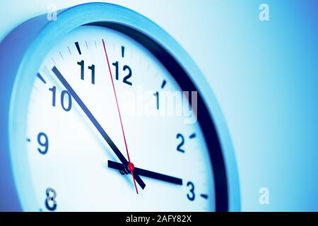 Closeup volte parte orologio appeso alla parete per le ore di lavoro blu tono di colore. Foto Stock