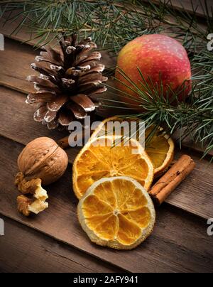 Sfondo autunnale con secchi Arance,di pino e cannella su legno Foto Stock