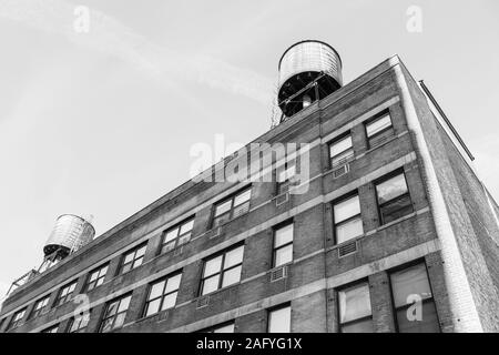 Immagine in bianco e nero di edificio di mattoni rossi a New York con torri d'acqua sul tetto Foto Stock