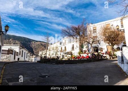 Capileira, La Alpujarra, Alpujarras, regione di Granada, Andalusia, Spagna. La piazza del paese in inverno il sole. Foto Stock