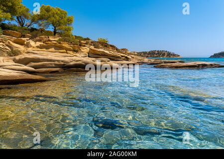 Alberi che crescono sulle rocce e mare in Grecia in orizzontale Foto Stock