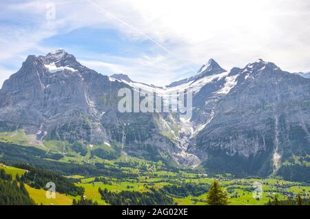 Estate paesaggio alpino intorno al paese di Grindelwald in Svizzera. Presa sul sentiero che conduce al lago Bachalpsee. Villaggio nella valle alpina circondata da foreste e montagne innevate. Foto Stock