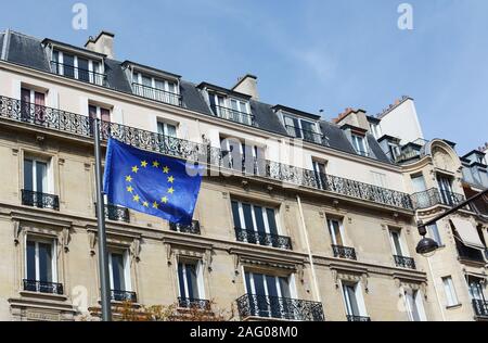 Parigi, Francia - 16 settembre 2019: bandiera UE con 27 stelle che rappresentano gli stati dell' Unione europea, mosche, sullo sfondo di un alloggiamento a Parigi Foto Stock