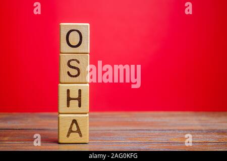 Blocchi di legno con la parola OSHA - La sicurezza e la salute sul lavoro di amministrazione. Foto Stock