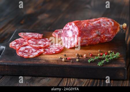 Salame con timo fresco sulla tavola di legno Foto Stock