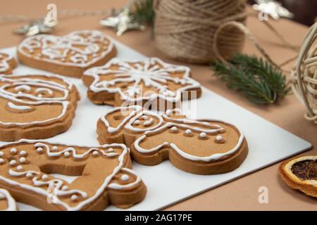 Il Natale di zenzero e miele biscotti sulla superficie bianca. Star, abete, forma il simbolo del fiocco di neve. Foto Stock