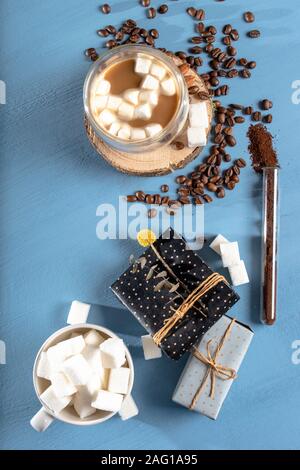 La tazza di tè o caffè con marshmallows. Zucchero e spezie. manciata di caffè baens. Le decorazioni di Natale. blu o sfondo aqua Foto Stock