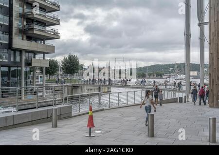 OSLO, Norvegia - 21 Luglio 2019: persone che passeggiano sui ponti pedonali tra architettura contemporanea a Tjuvholmen rinnovamento urbano intorno , girato onu Foto Stock