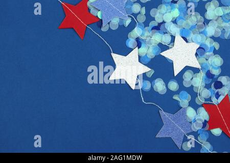 Ghirlanda di stelle colorate e coriandoli punti sul classico sfondo blu. Foto Stock