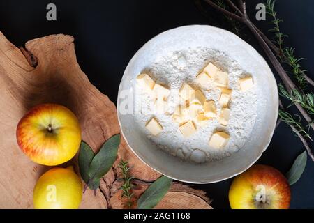 Preparazione alimentare concetto ingredienti per fare base di pastafrolla per torta burro freddo e farina su nero con spazio di copia Foto Stock