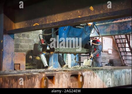 Lavoratori opera la macchina con le cazzuole Foto Stock