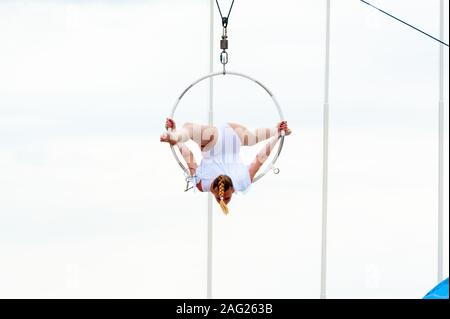 Grazioso acrobat esegue la ginnastica trick sull'hoop Foto Stock