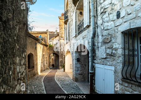 Una stretta di ciottoli, vicolo di pietra attraverso la collina della città medievale di Saint Paul de Vence, Francia al tramonto. Foto Stock