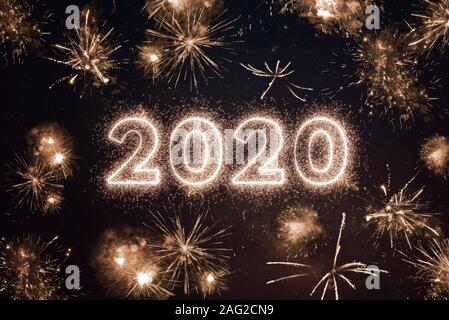 2020 anno scritto con sparkle fuochi d'artificio del cielo notturno. Felice Anno Nuovo 2020 saluto Foto Stock