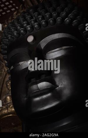 Primo piano della statua del Grande Buddha faccia in Daibutsuden, Grande Buddha Hall di Tempio di Todai-ji il tempio Todaiji, sala principale, a Nara, Giappone. Foto Stock
