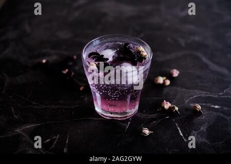 Pink gin tonic cocktail con Hibiscus e essiccato boccioli di rosa Foto Stock