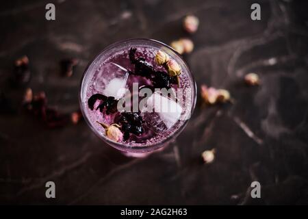 Pink gin tonic cocktail con Hibiscus e essiccato boccioli di rosa Foto Stock