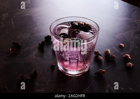 Pink gin tonic cocktail con Hibiscus e essiccato boccioli di rosa Foto Stock