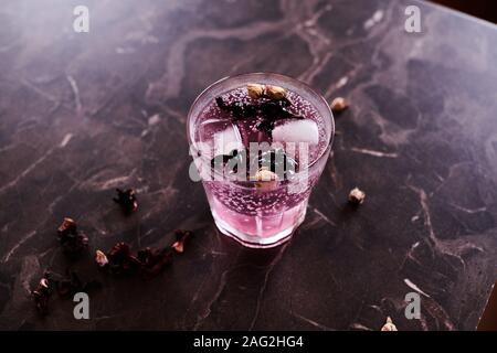 Pink gin tonic cocktail con Hibiscus e essiccato boccioli di rosa Foto Stock