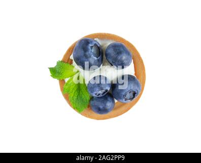 Foto macro di pasticcini con mirtillo, mirtilli e foglie di menta isolati su sfondo bianco. Torte con crema di formaggio e di mirtilli freschi Foto Stock