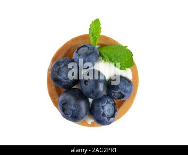 Foto macro di pasticcini con mirtillo, mirtilli e foglie di menta isolati su sfondo bianco. Torte con crema di formaggio e di mirtilli freschi Foto Stock