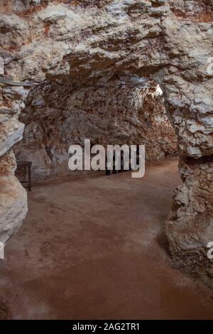 Vecchie bottiglie di vino sul pavimento di una grotta Foto Stock