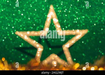 Defocalizzata golden decorazioni di Natale su erba cipollina sfondo verde. Foto Stock