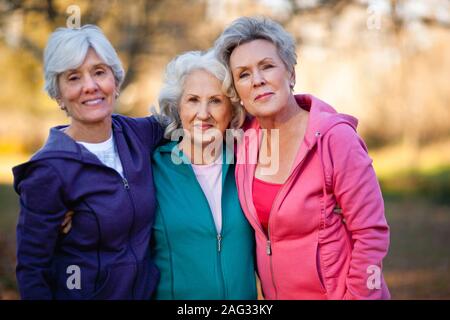 Ritratto di tre donne sorridente con le braccia intorno all'altro. Foto Stock