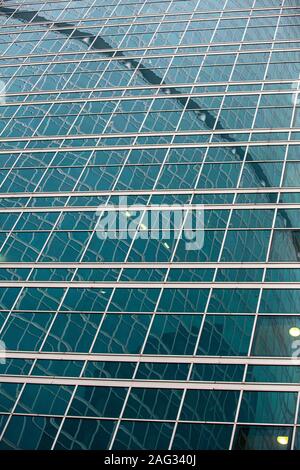 Frammento di edificio moderno. Close-up. Una bella combinazione di metallo e vetro. Di rifrazione efficace delle strutture nelle superfici lucide. Foto Stock
