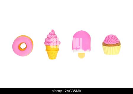 Diversi dolci giocattolo in miniatura con le ombre morbide close-up isolato su uno sfondo bianco. Foto Stock