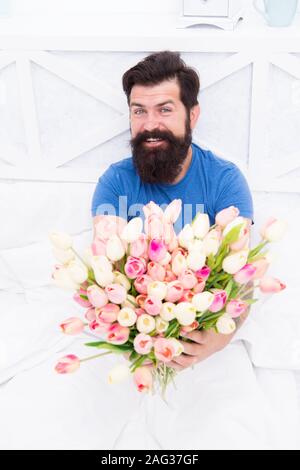 Il tempo per rilassarsi. per il vostro amato. la felicità reale. Felice uomo barbuto in letto. regalo di compleanno bouquet. molla tulip fresco. amore il giorno di San Valentino. womens giorno. tulip fiore per marzo 8. buona mattina fiori. Foto Stock