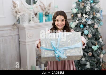 Tutto ciò di cui avete bisogno per il periodo natalizio. Felice ragazza dare il regalo di Natale. Piccolo bambino di festeggiare il Natale e il nuovo anno. Boxing day. La vigilia di Natale. Felice Anno Nuovo. Merry Xmas. Preparazione per le vacanze. Giveaway del tempo. Foto Stock