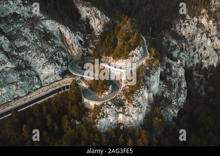 Strada curva sulla montagna con verde bosco in autunno Foto Stock