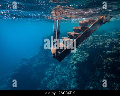 Primo piano di una scalinata in metallo arrugginito sotto il mare Foto Stock