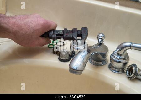 Angolo laterale foto di un rubinetto rotto con un mans mano. Ottimo per una tubazione o tuttofare annuncio. Foto Stock