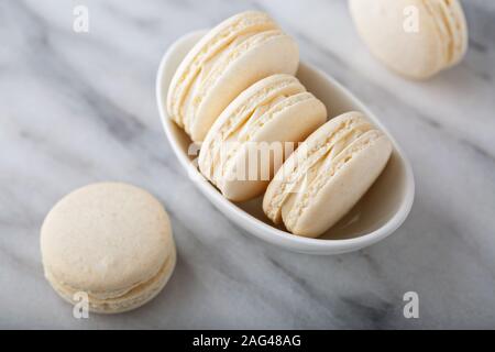 La vaniglia macarons in una piccola ciotola Foto Stock