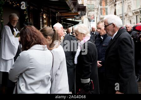 Harrods, Hans Crescent, Londra, Regno Unito. 17 dicembre 2019. 1.20pm. I superstiti, amici e famiglie del 1983 magazzini Harrods attentato si riuniscono per commemorare la polizia e i civili uccisi o feriti quando l'ira posto un auto bomba al di fuori di questo iconico London store l'ultimo sabato prima di Natale. Foto Stock