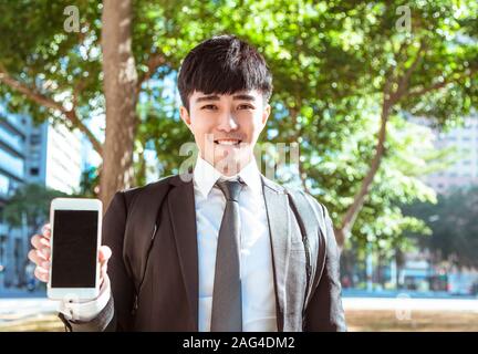 Business man mano che mostra vuoto smart schermata telefono Foto Stock