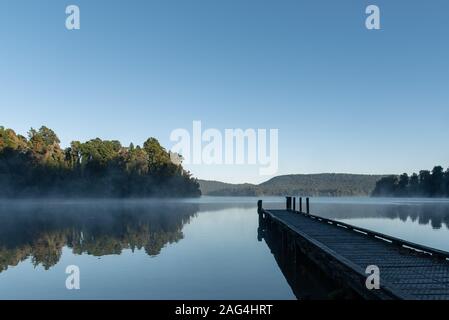 Bella foto del lago Mapourika in Nuova Zelanda circondato da un paesaggio verde Foto Stock