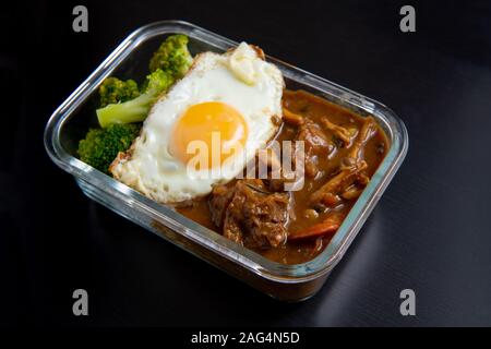 Carni bovine di riso al curry in vetro scatola di pranzo su nero tavolo da pranzo in legno ( Onsen tamago, patata, enoki funghi, cipolla, broccoli, in stile giapponese) Foto Stock