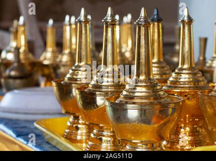 Fila di golden flagons sul vassoio per la dedizione alla morte Foto Stock