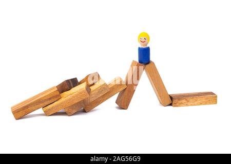 Un piccolo giocattolo di legno un ragazzo sorge su un ampio numero di fiocchi di legno su un bianco sfondo isolato Foto Stock