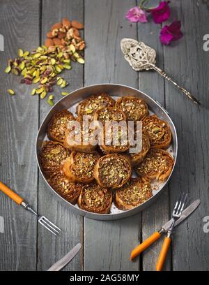 Colpo ad angolo alto di rotoli fatti con semi di zucca e. mandorle in una pentola di metallo su una superficie di legno Foto Stock