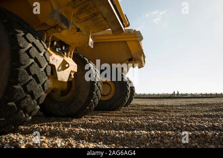 Immagine di basso livello di grandi macchine che creano difese di erosione delle maree sulla spiaggia di Seaford East Sussex Foto Stock