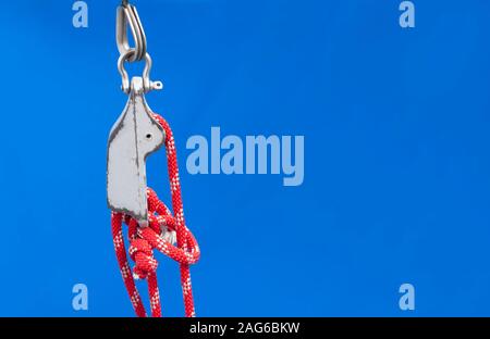 Nodo nautico su red corde e affrontare il problema di una barca blu su sfondo tessili. Grande copy-spazio per collocare il testo. Foto Stock