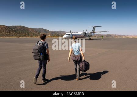 Etiopia, Amhara, Lalibela, Aeroporto, giovani turisti a piedi verso le compagnie aeree Bombardier Q400, Dash 8 aeromobile Foto Stock