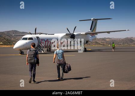 Etiopia, Amhara, Lalibela, Aeroporto, giovani turisti camminare sull'area di stazionamento verso le compagnie aeree Bombardier Q400, Dash 8 aeromobile Foto Stock