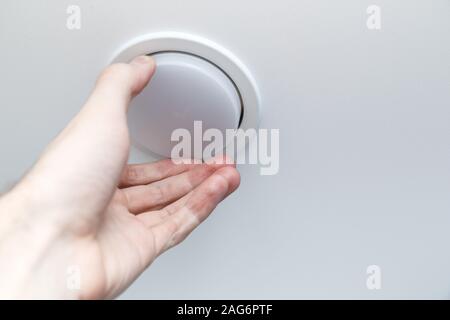 Mano trattiene un LED lampada a basso consumo di potenza, la sostituzione delle lampadine delle luci sul soffitto. Foto Stock