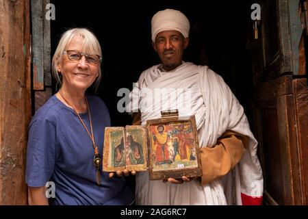 Etiopia, Amhara, Lalibela, Mount Abuna Yosef, all'interno, Asheton Maryam Monastero, mostrando antica icona dipinta a senior turista femminile Foto Stock